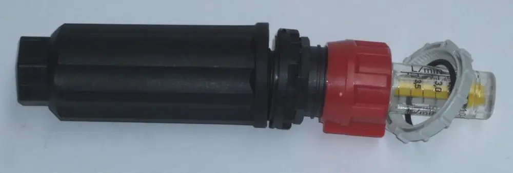 Daikin Durchflussmesser mit roter und grauer Kunststoffkappe, transparentem Messzylinder, der Durchflusswerte anzeigt, zur Verwendung in Fußbodenheizungsverteilern.